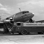 Заправка топливом самолета DC-3 на летном поле аэропорта Схипхол, на заднем плане - здание аэропорта и диспетчерская вышка, 1938 год